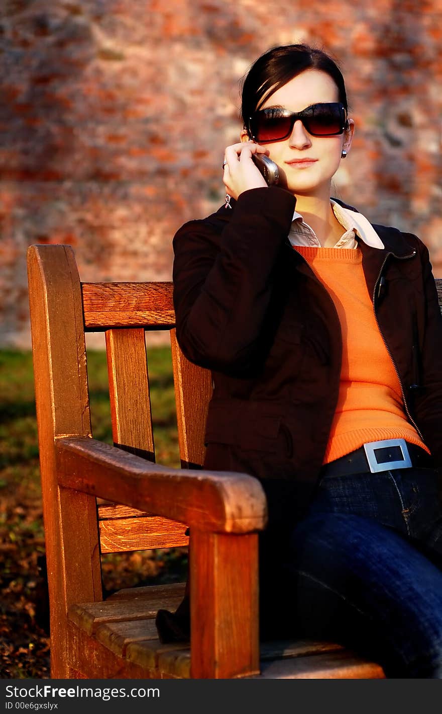 Photo of pretty female in sunshine light with cell phone. Photo of pretty female in sunshine light with cell phone.