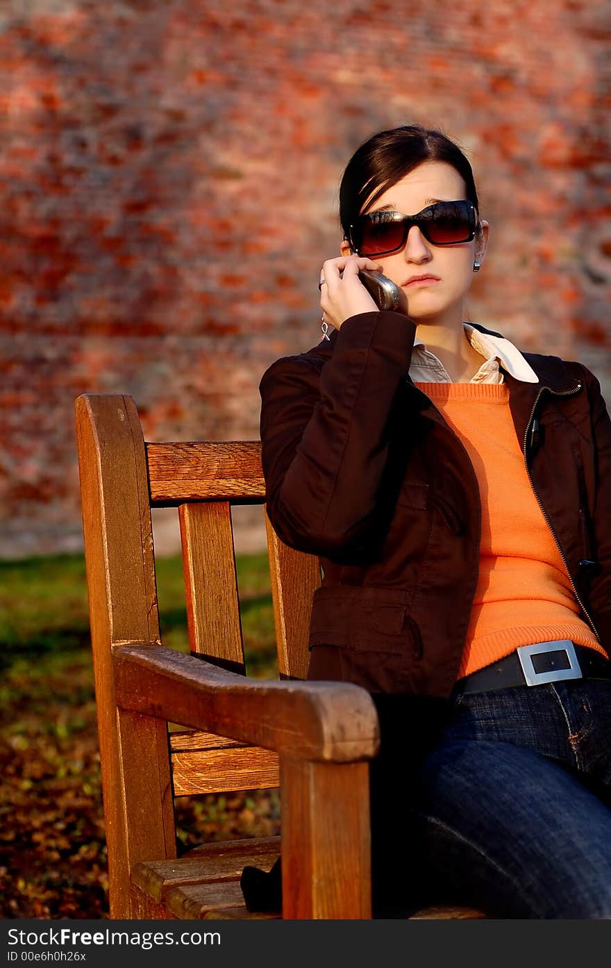 Photo of pretty female in sunshine light with cell phone. Photo of pretty female in sunshine light with cell phone.