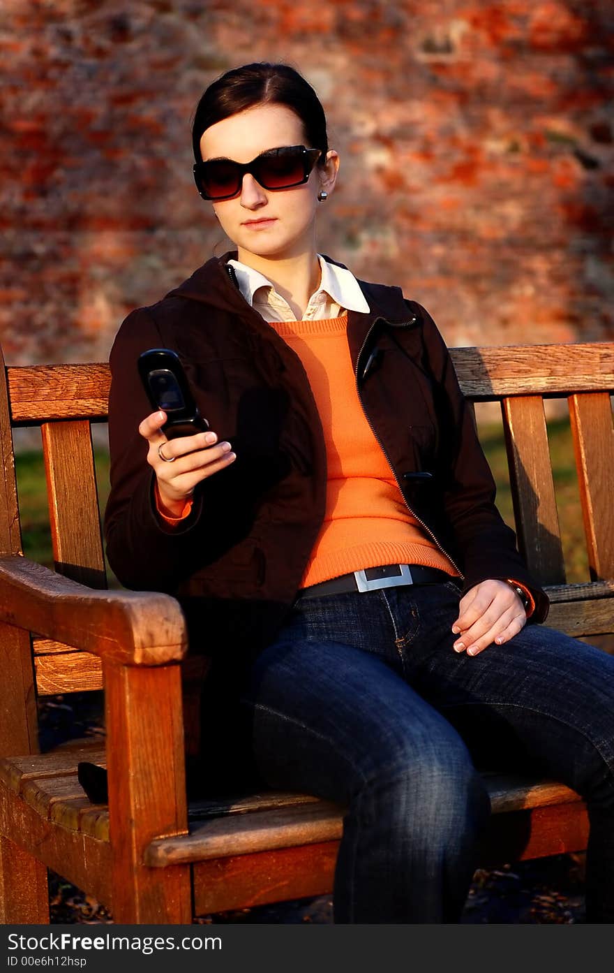 Photo of pretty female in sunshine light with cell phone. Photo of pretty female in sunshine light with cell phone.