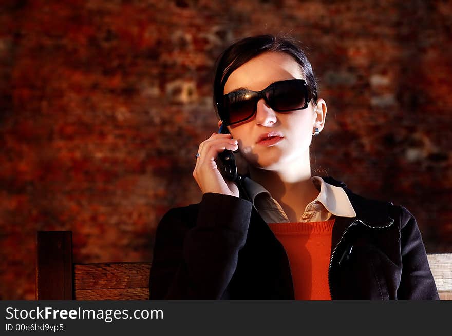 Photo of pretty female in sunshine light with cell phone. Photo of pretty female in sunshine light with cell phone.