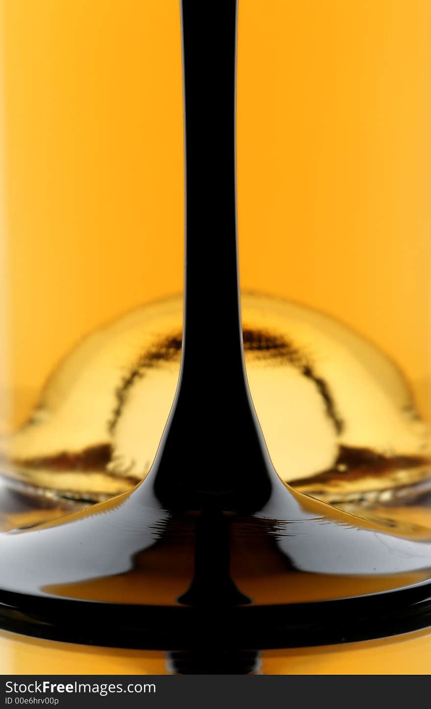 Bottom of wine glass in front of bottom of wine bottle. Bottom of wine glass in front of bottom of wine bottle.