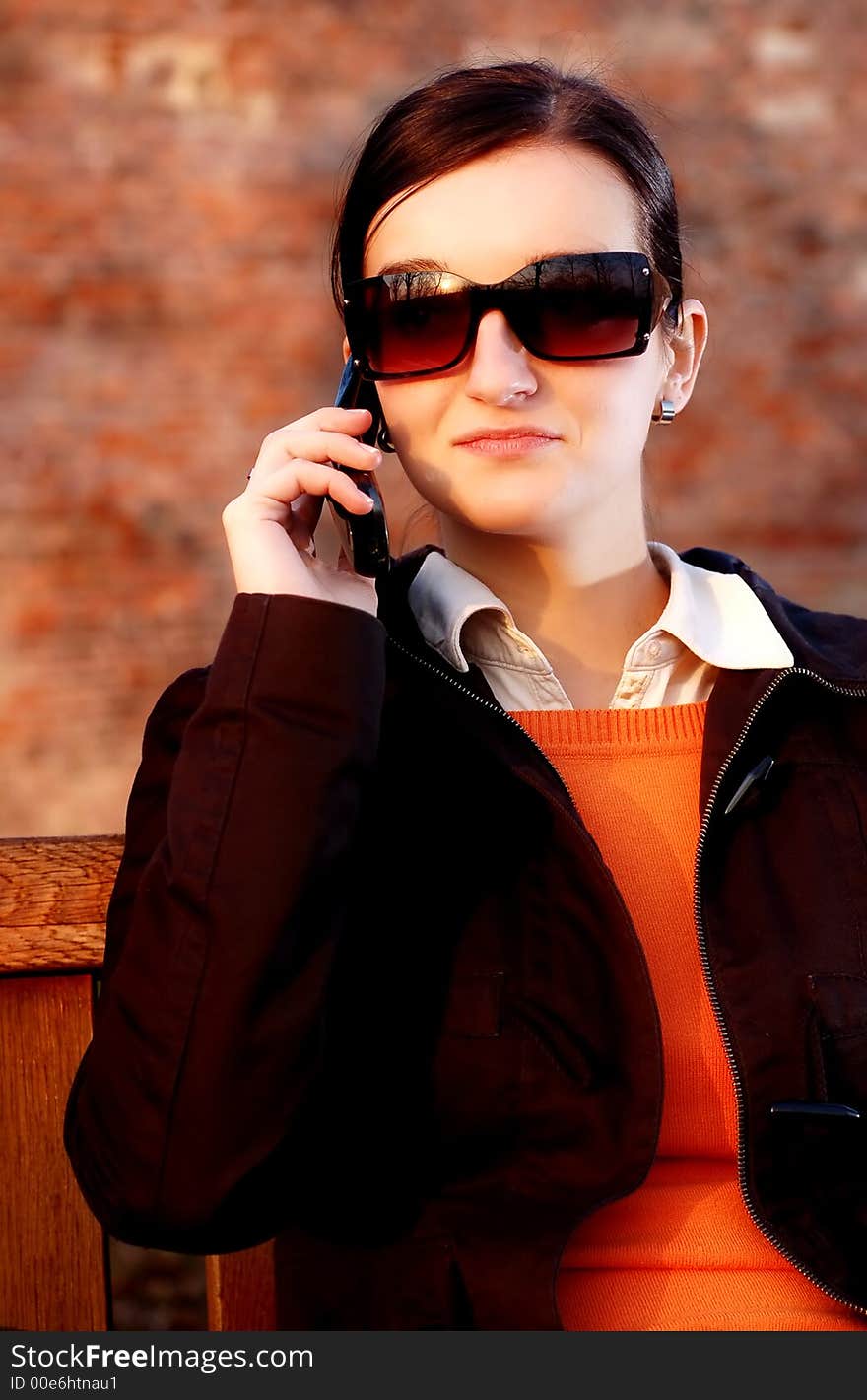 Photo of pretty female in sunshine light with cell phone. Photo of pretty female in sunshine light with cell phone.