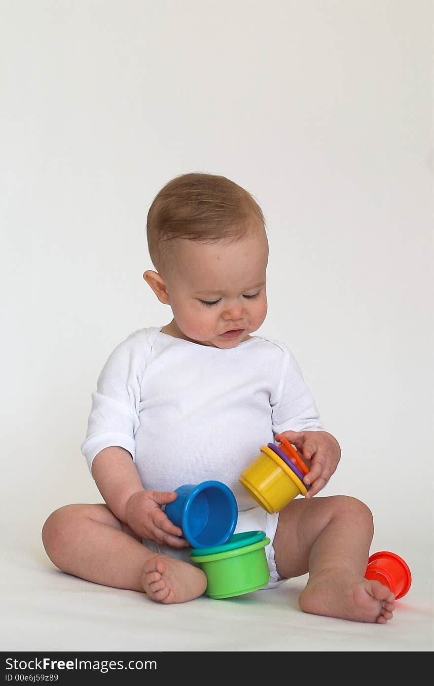 Image of adorable baby playing with stacking cups. Image of adorable baby playing with stacking cups