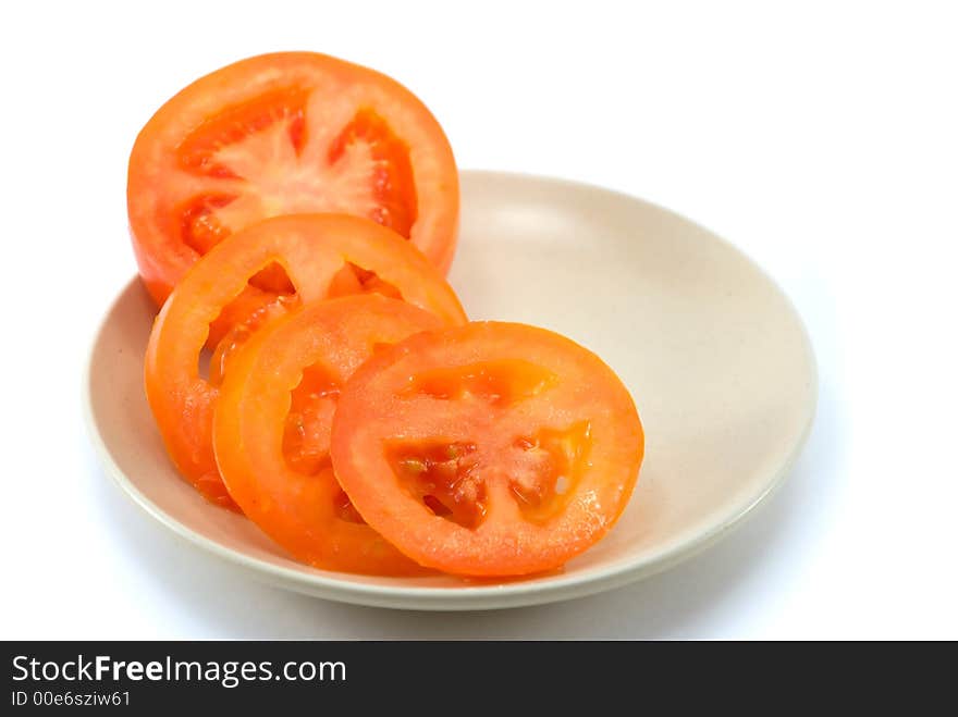 The beautiful cut tomato on a plate on a white background