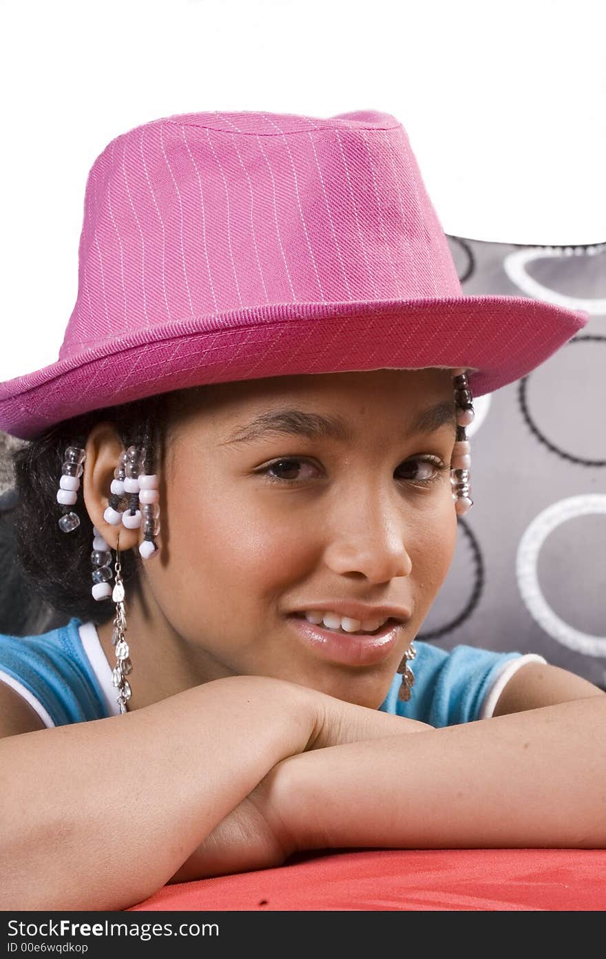 Cute african american girl resting head on hands and pink hat on head