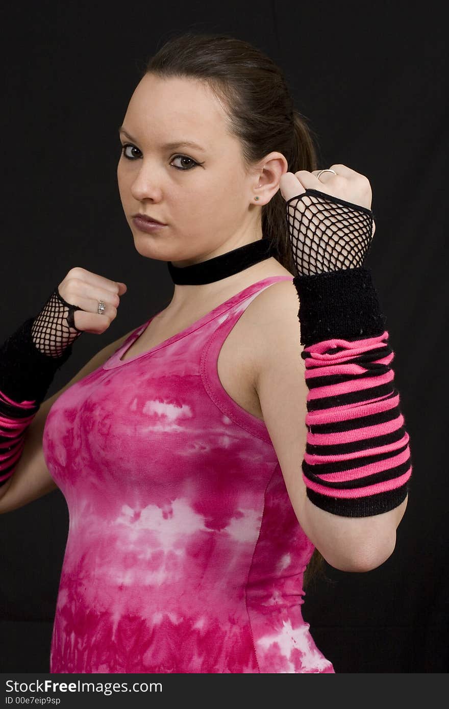 A young woman in a pink top looking aggresively towards camera. A young woman in a pink top looking aggresively towards camera