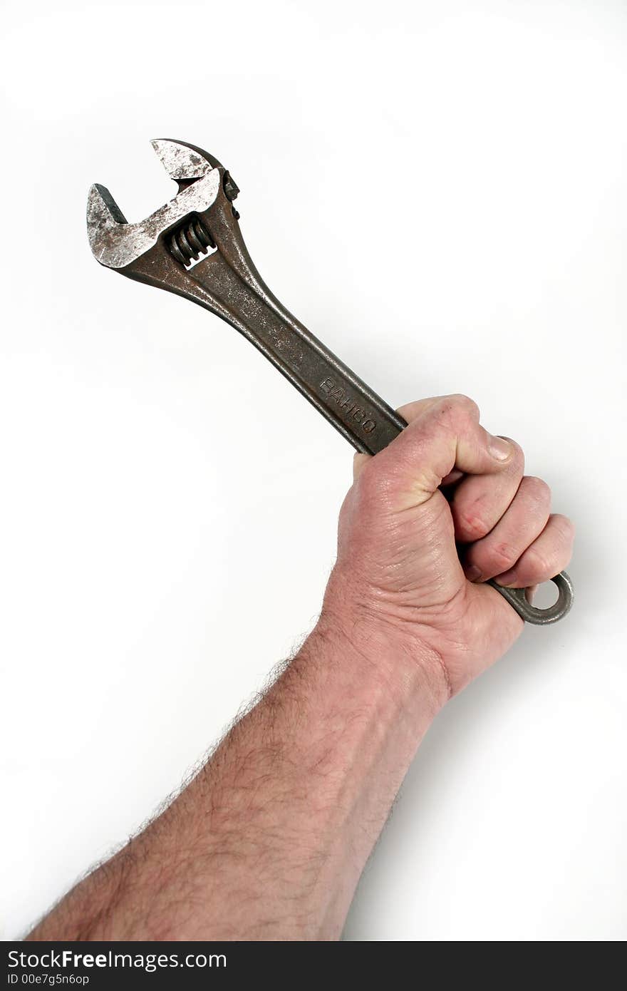 A hand clutching a monkey wrench on a white background. A hand clutching a monkey wrench on a white background.