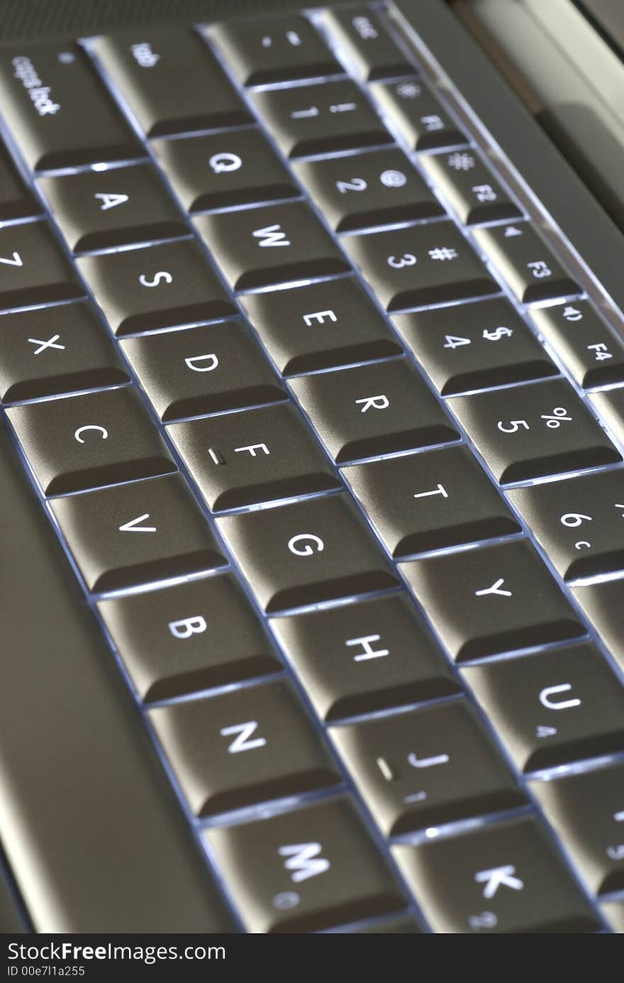 A closeup of a backlit computer keyboard with shallow depth of field.