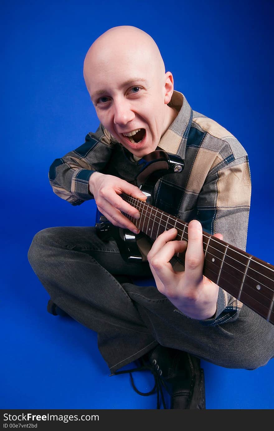 The musician smiles on a blue background