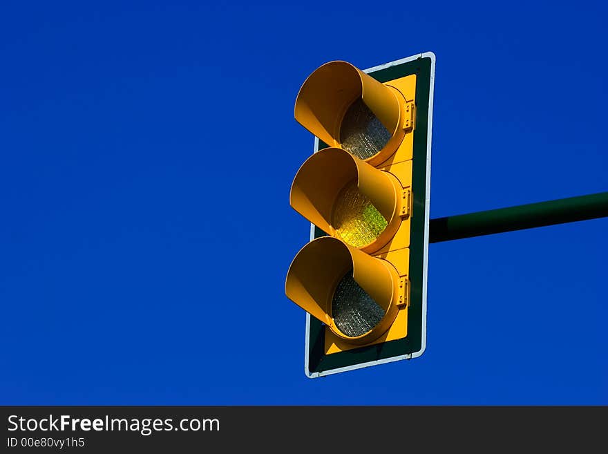 Yellow traffic light on blue sky