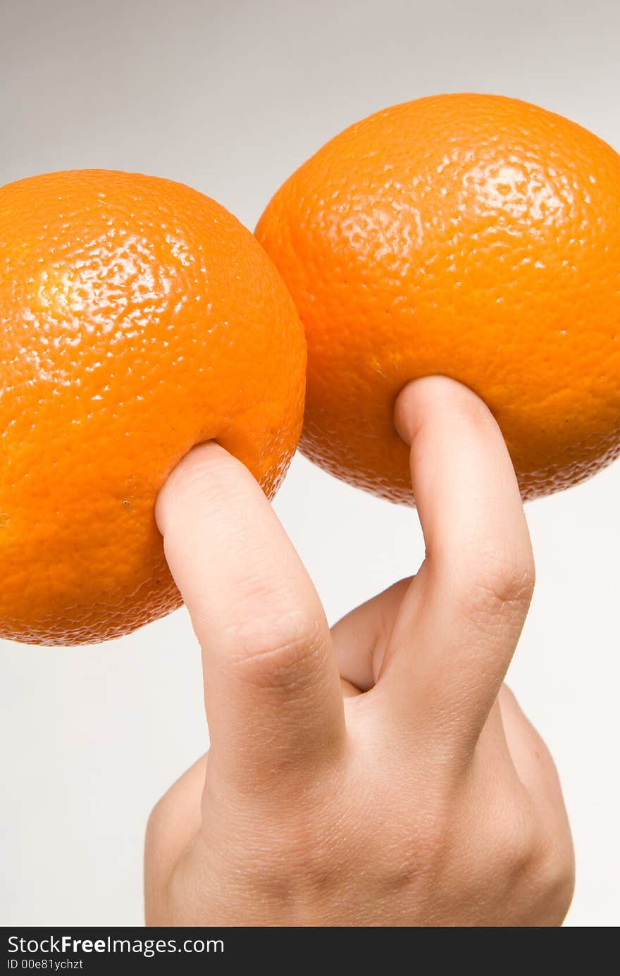 Two colorful oranges on fingers. Two colorful oranges on fingers