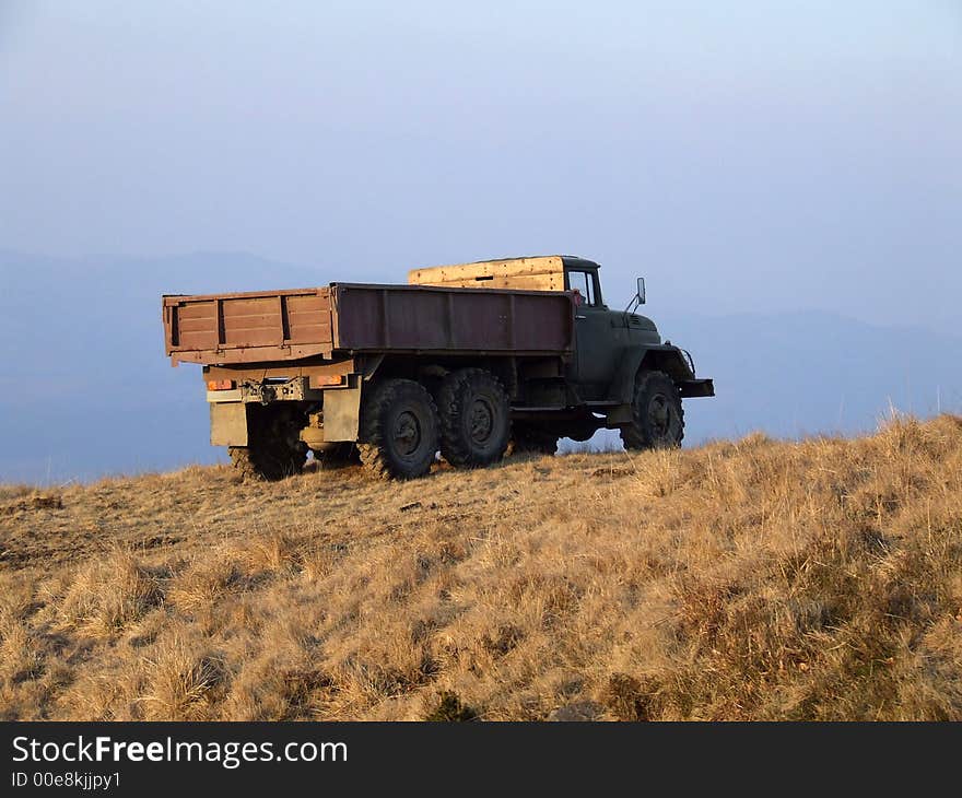 Old truck standing on the hill against the sky. Old truck standing on the hill against the sky