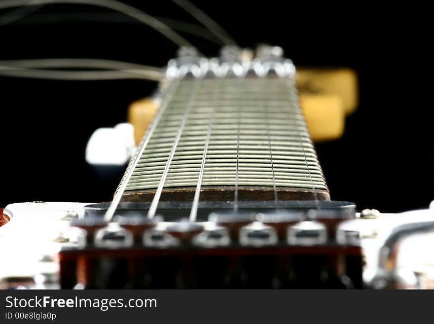 Close up at electric guitar fingerboard with focus set on highest frets. Close up at electric guitar fingerboard with focus set on highest frets