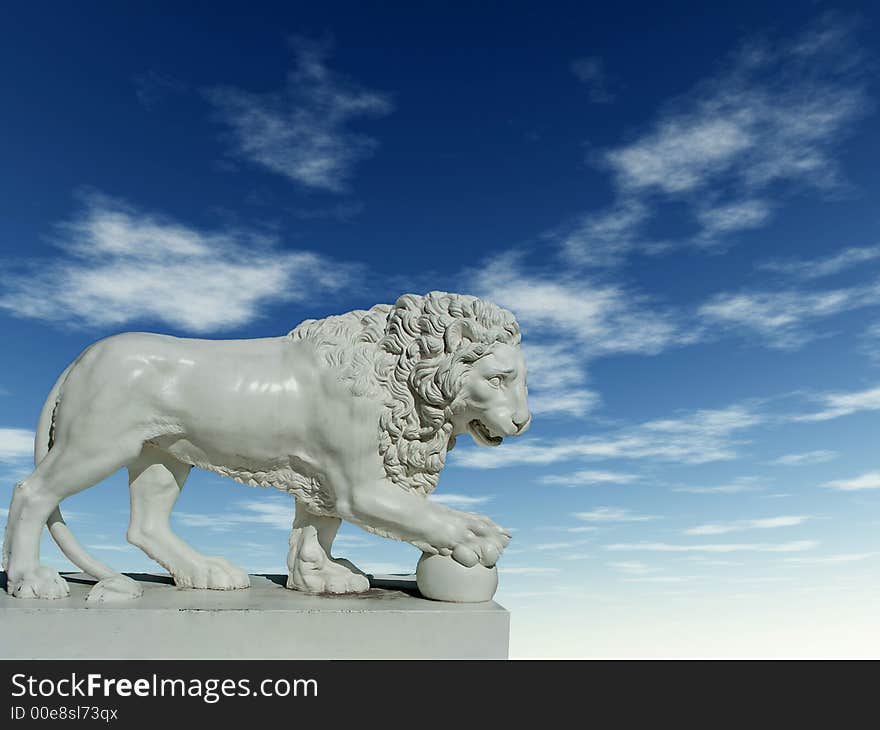 Sculpture of a white lion on a background of the blue sky