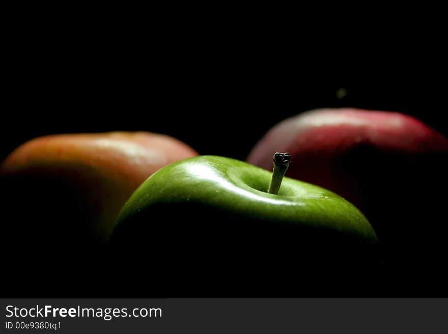 Colourful juicy apples against a black back ground