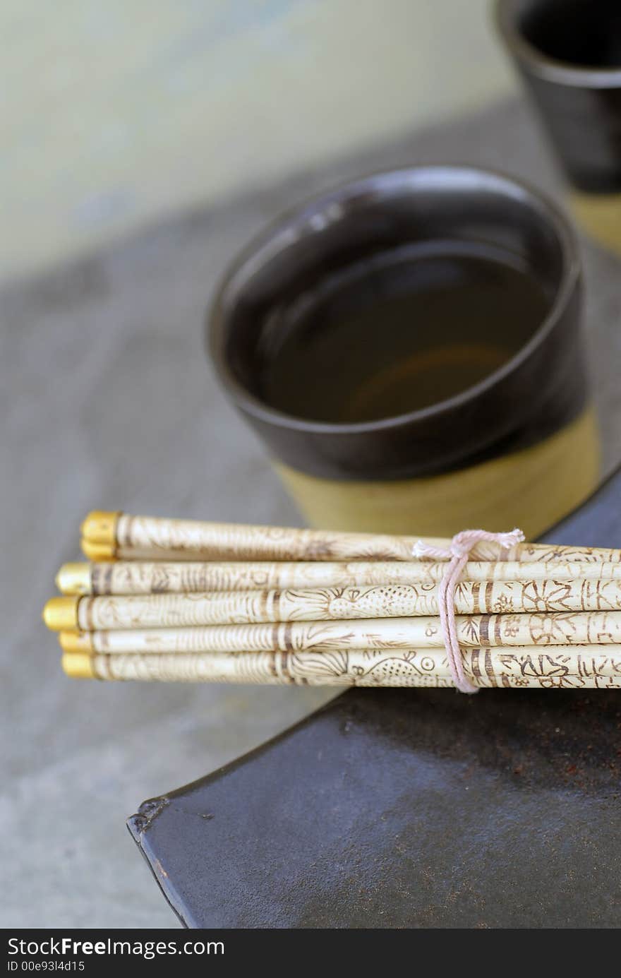 Tea bowls and chopsticks still life photograph. Shallow depth of focus, focus on the foreground. Tea bowls and chopsticks still life photograph. Shallow depth of focus, focus on the foreground.