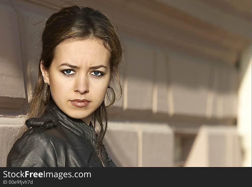 Attractive young woman posing leaning against a wall