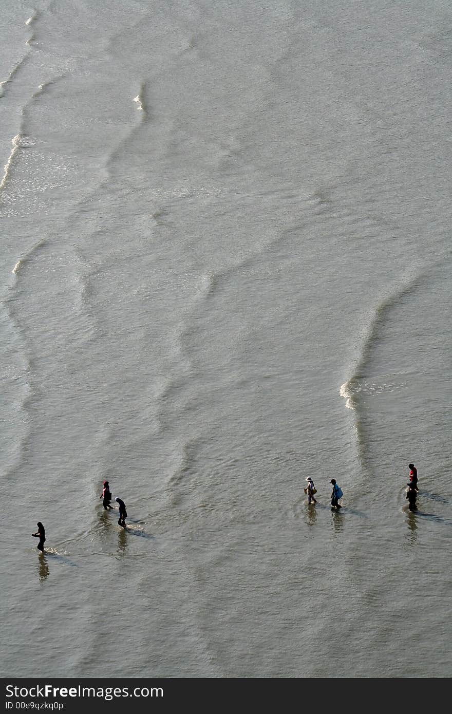 People being dropped off from a taxi boat making their way to the beach. People being dropped off from a taxi boat making their way to the beach