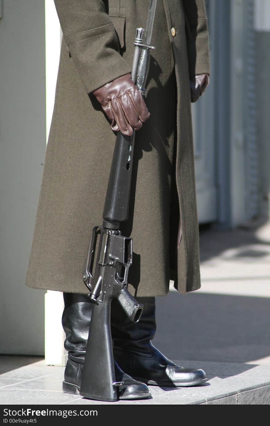 Soldier standing on guard with automatic rifle