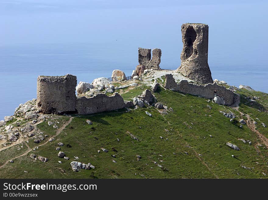 Ruins of an ancient fortress above the blue sea