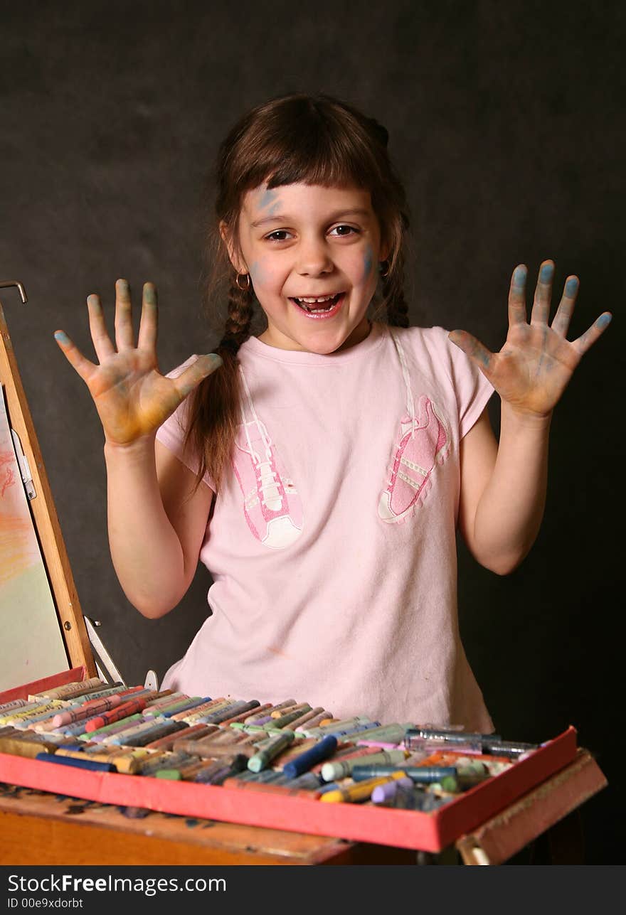 The good little girl. Hands and the face are soiled in a paint. The good little girl. Hands and the face are soiled in a paint