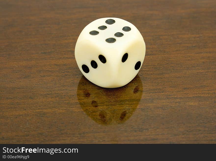 Dice (six) with reflection on wooden table