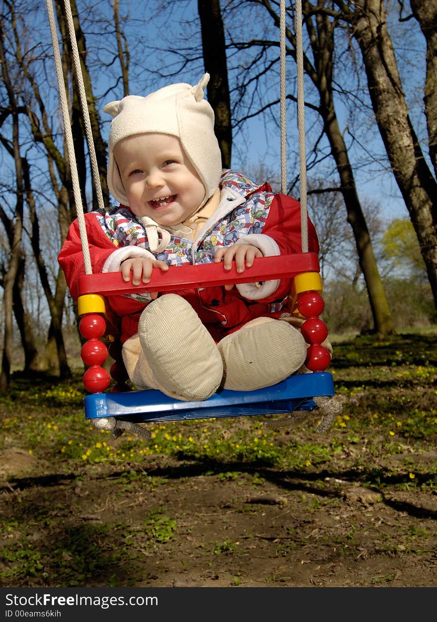 Little boy swings and smiles. Little boy swings and smiles