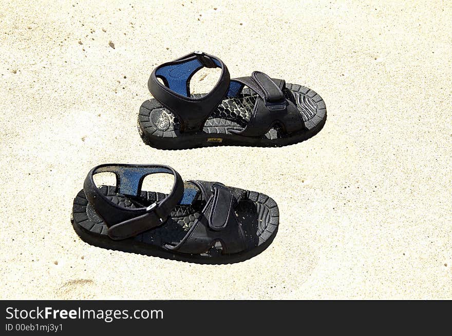 A pair of sandals on the beach shores. A pair of sandals on the beach shores