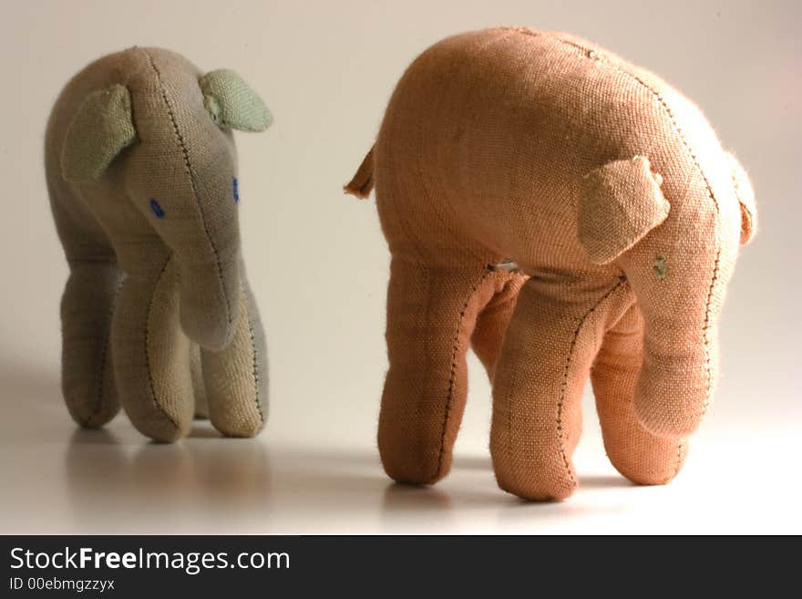 Small stuffed elephants isolated on white background following each other. Small stuffed elephants isolated on white background following each other