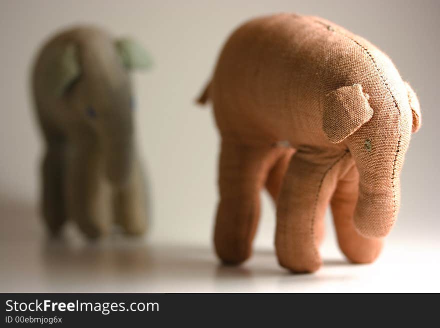 Small stuffed elephants isolated on white background following each other. Small stuffed elephants isolated on white background following each other