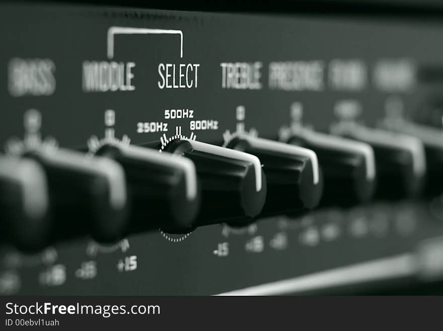 Close-up of the hi-end audio amplifier controls, dark green monochrome. Shallow DOF (focus is on the SELECT knob). Close-up of the hi-end audio amplifier controls, dark green monochrome. Shallow DOF (focus is on the SELECT knob)