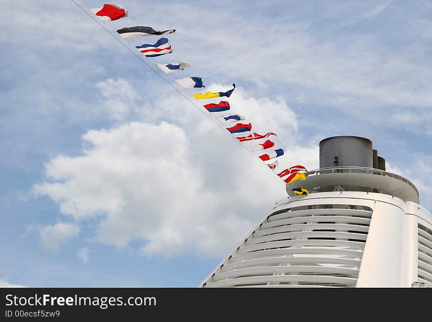 A ships smokestack and nautical flags against sky. A ships smokestack and nautical flags against sky