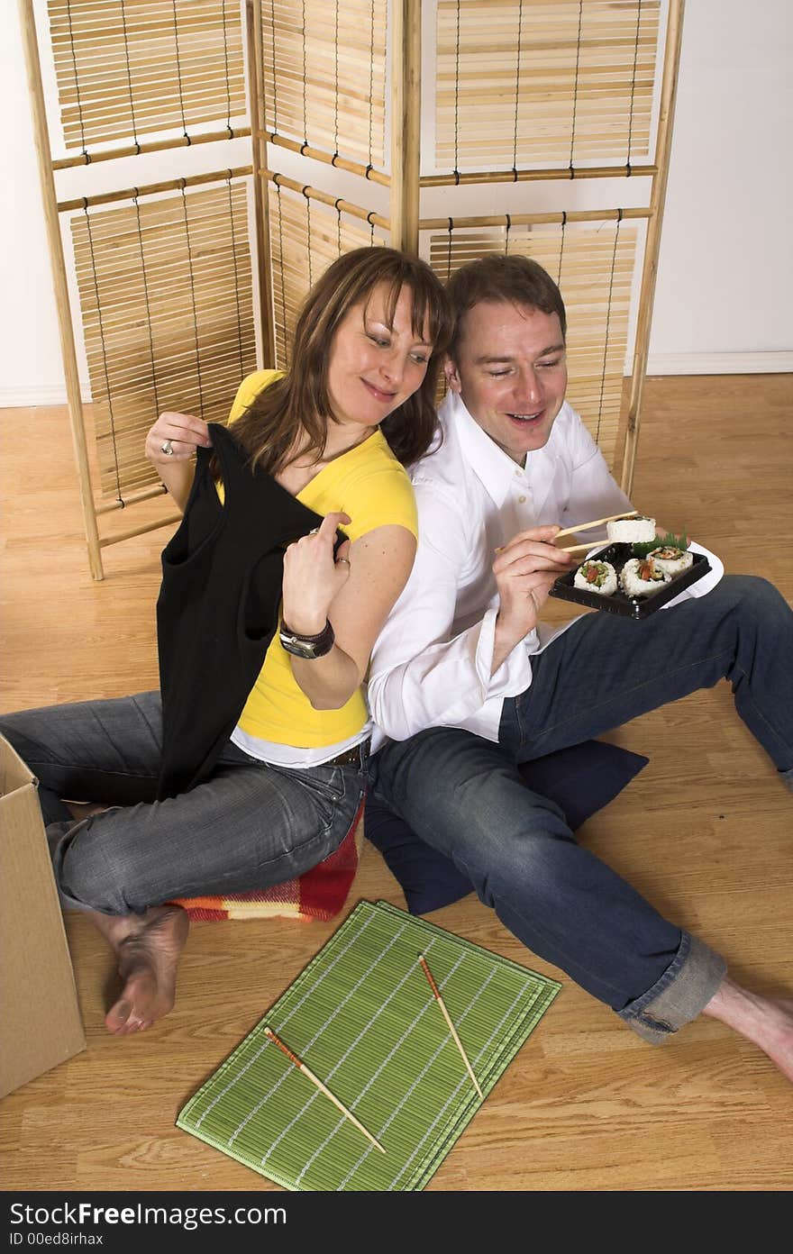 Happy couple moving in new place eating sushi