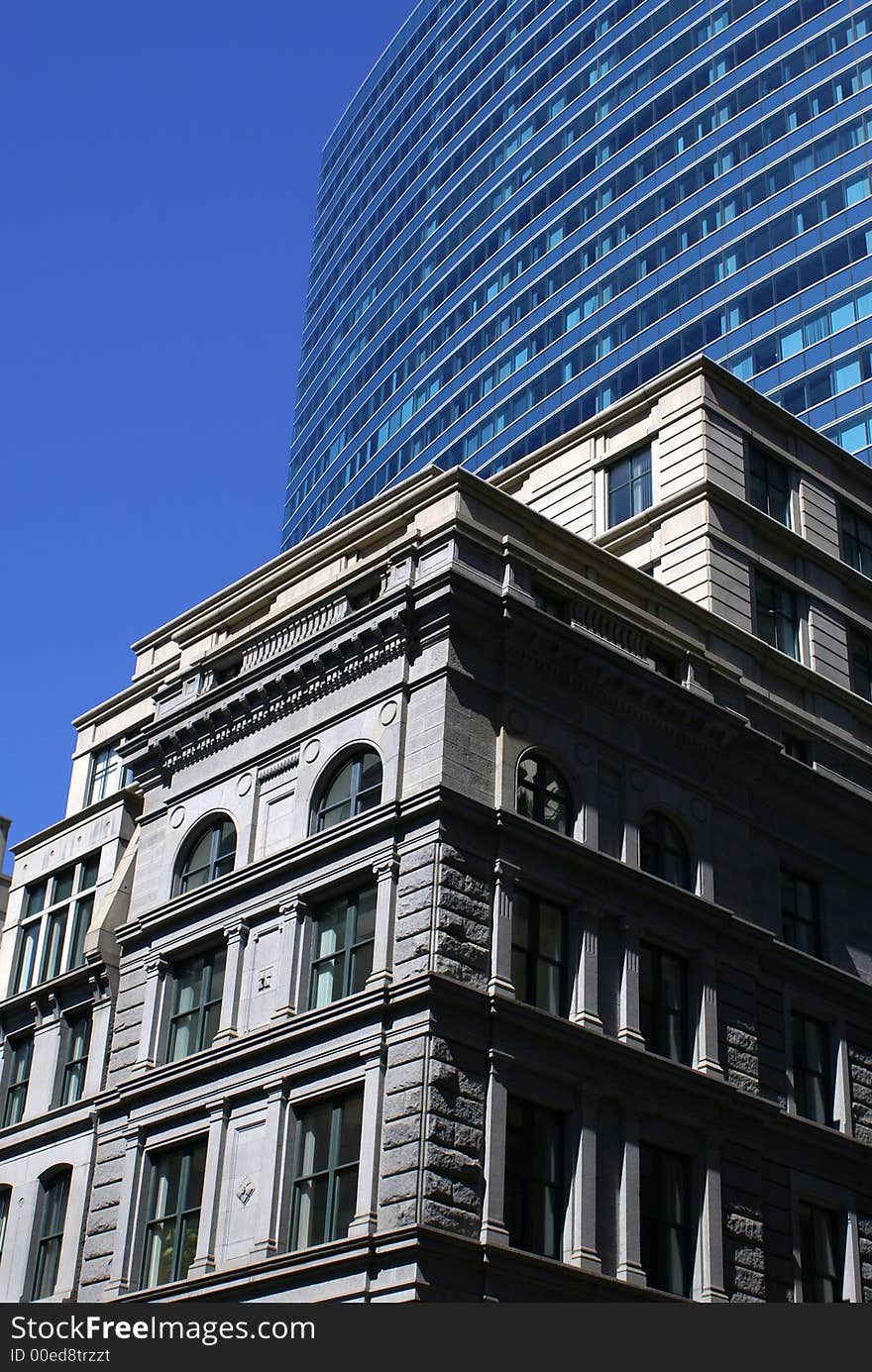 Old stately building in downtown boston against a deep blue sky with modern building in background