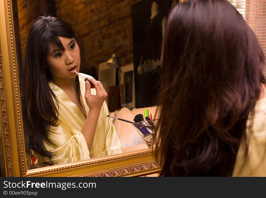 Reflection of girl applying lipstick. Reflection of girl applying lipstick