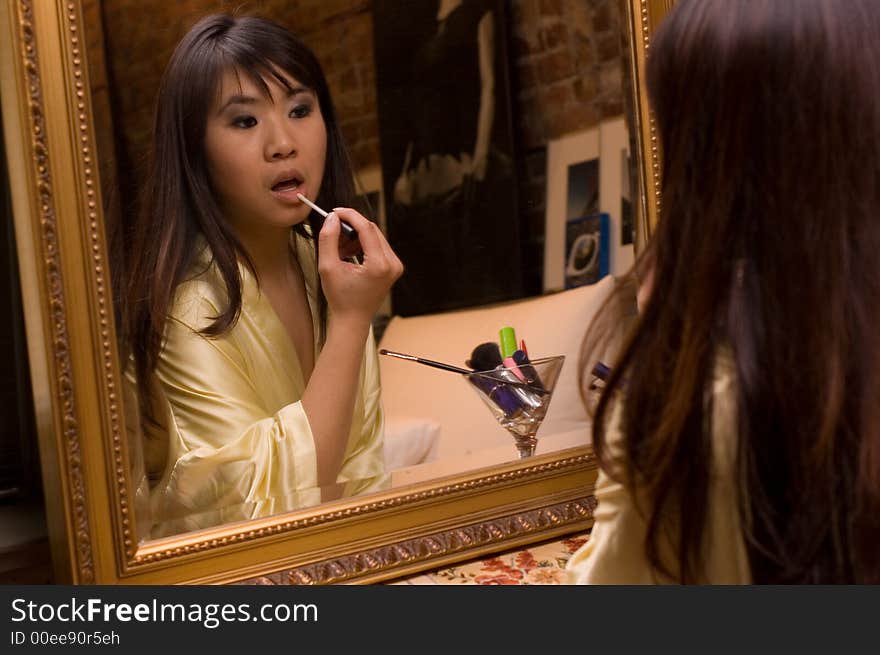 Reflection of girl applying lipstick. Reflection of girl applying lipstick