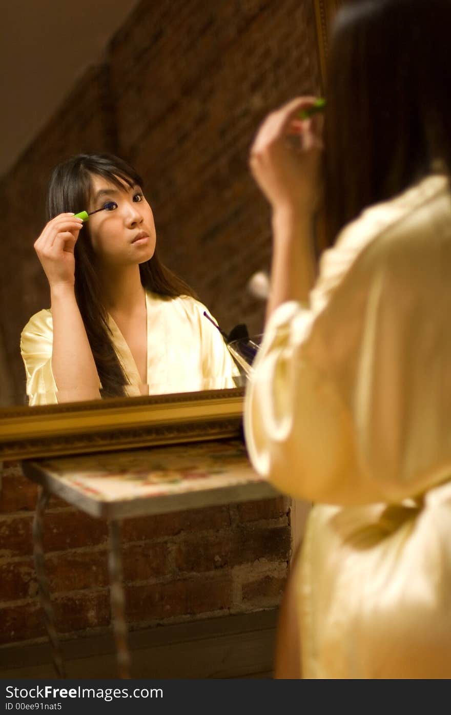 Reflection of girl applying eye makeup. Reflection of girl applying eye makeup