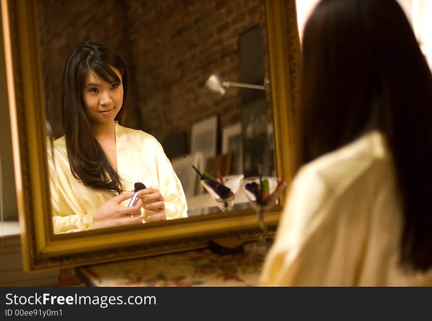 Reflection of pretty asian girl in a bathrobe smiling. Reflection of pretty asian girl in a bathrobe smiling