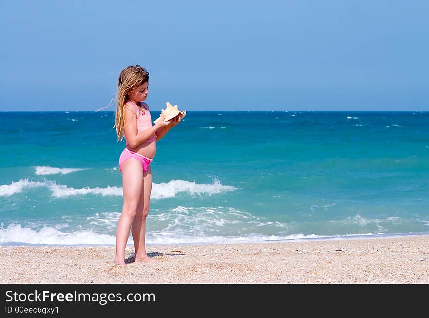 Young girl finds shell on beach. Atlantic Ocean, Florida east coast. Young girl finds shell on beach. Atlantic Ocean, Florida east coast