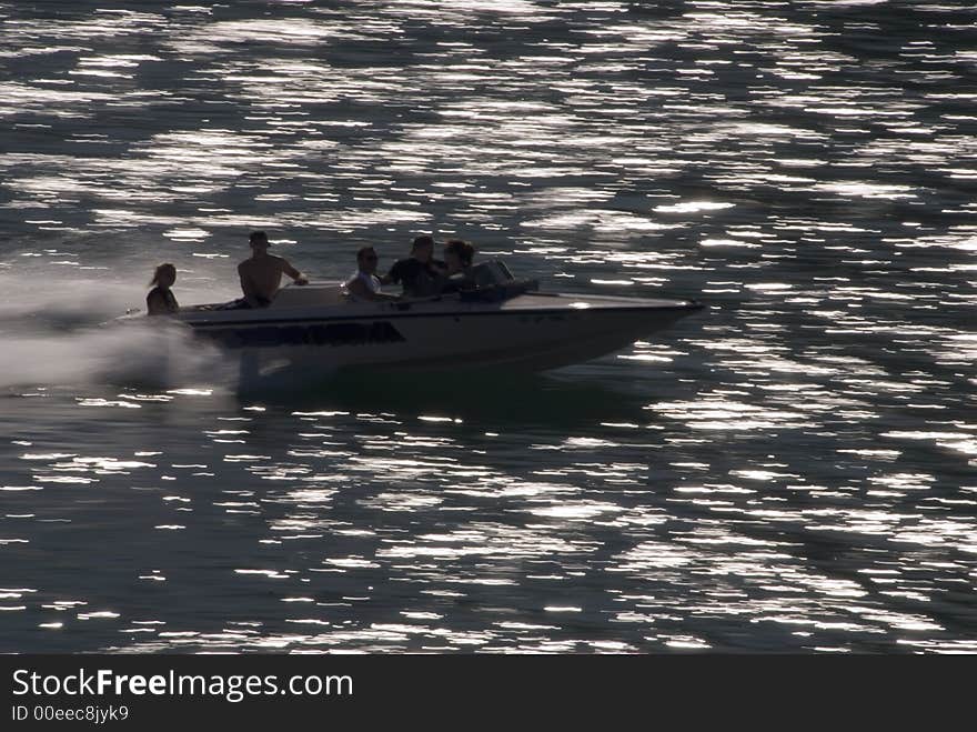 Boat showing motion in water with people and light streaks. Boat showing motion in water with people and light streaks