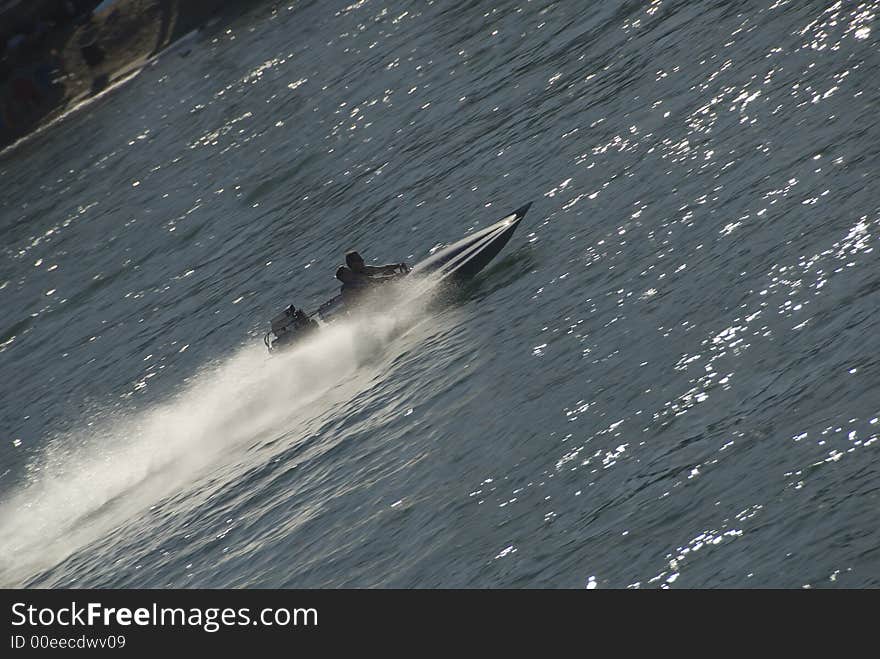 Fast moving boat crossing lake in diagonal with highlights. Fast moving boat crossing lake in diagonal with highlights