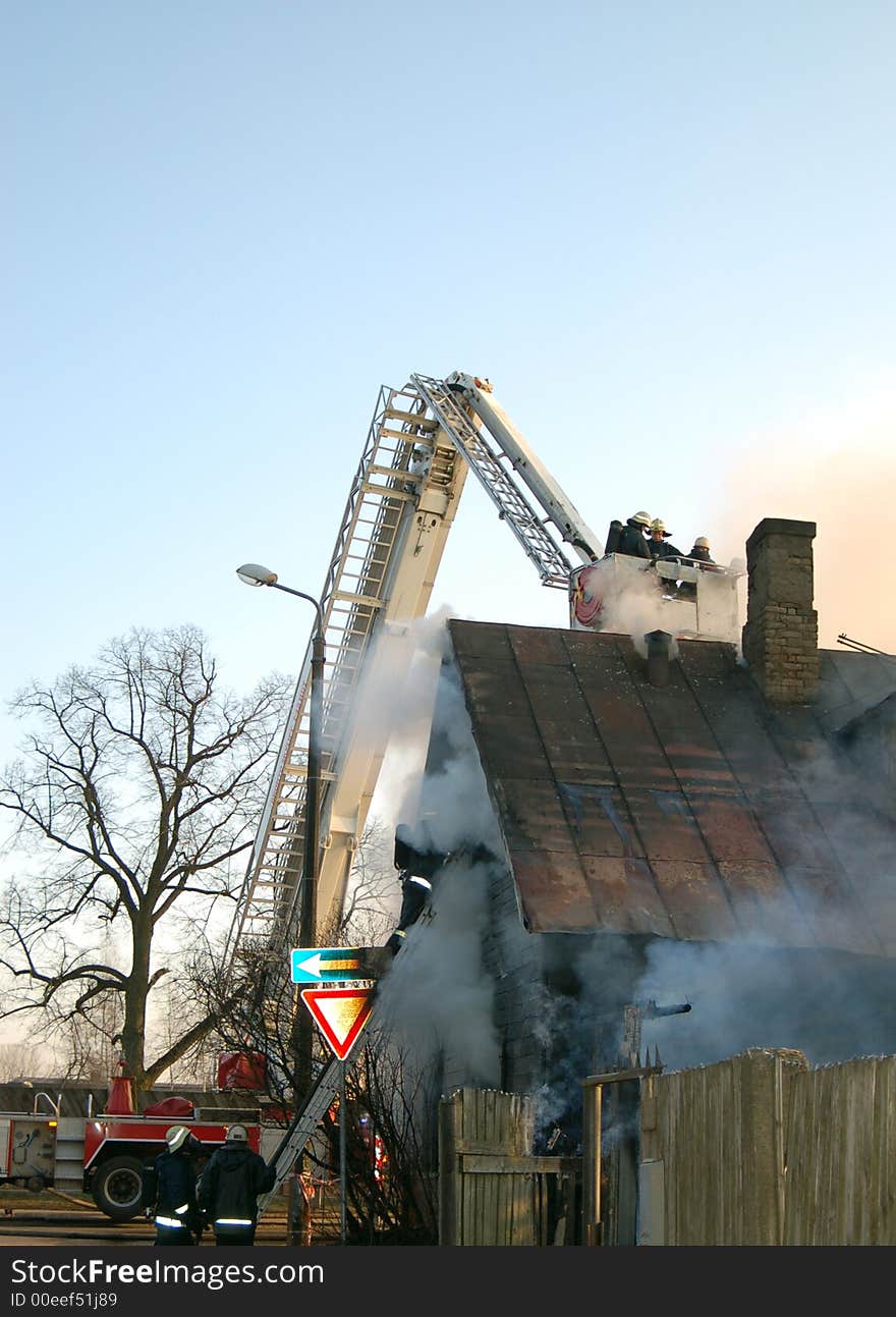 Firemen at work, Old wooden house in fire