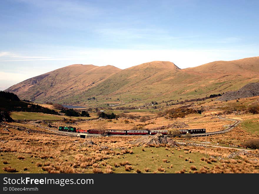 Steam train running through the mountains on the Welsh Highland Railway, Wales, UK. Steam train running through the mountains on the Welsh Highland Railway, Wales, UK