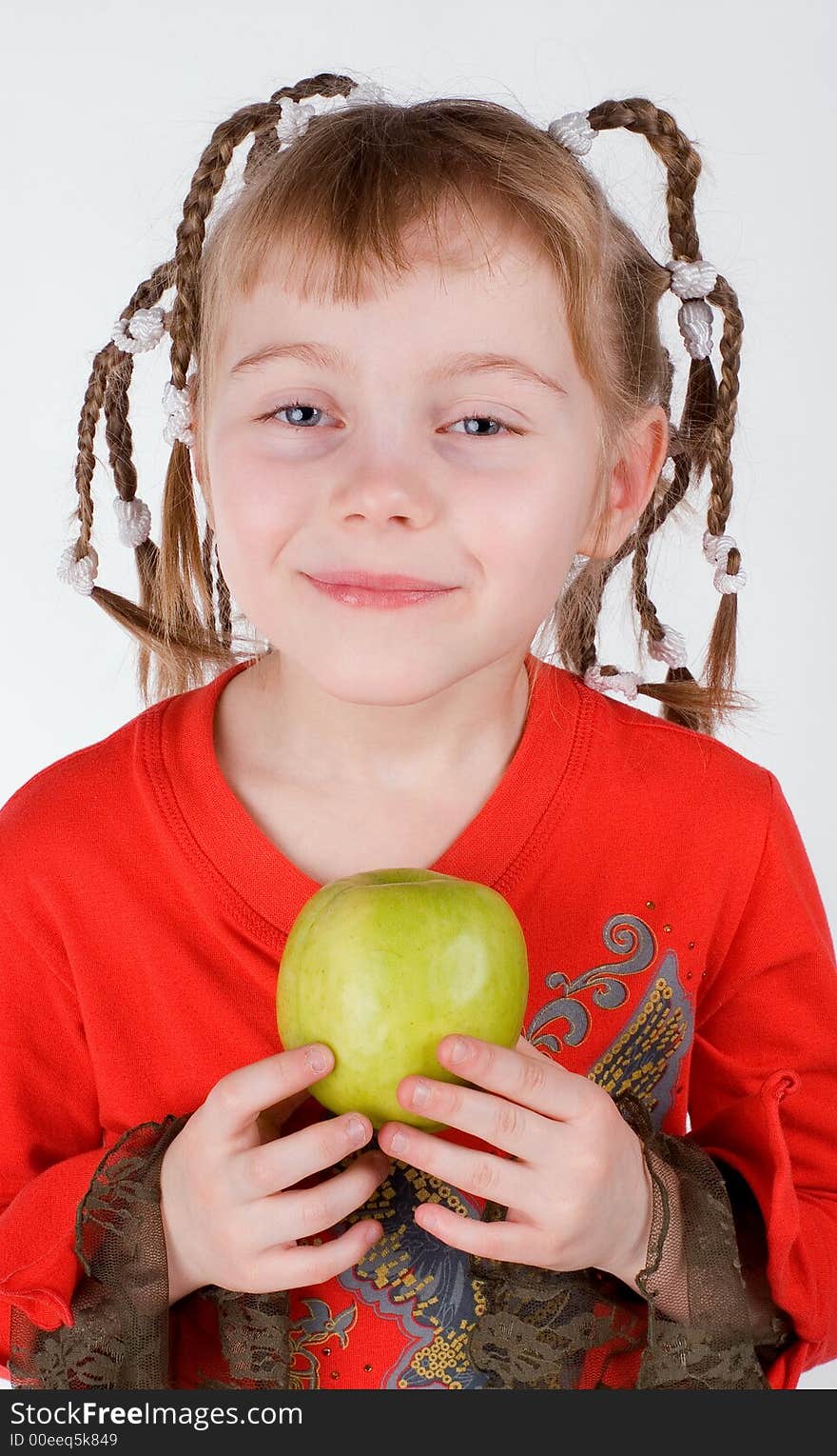 The girl in a red dress with an apple on a white background. The girl in a red dress with an apple on a white background