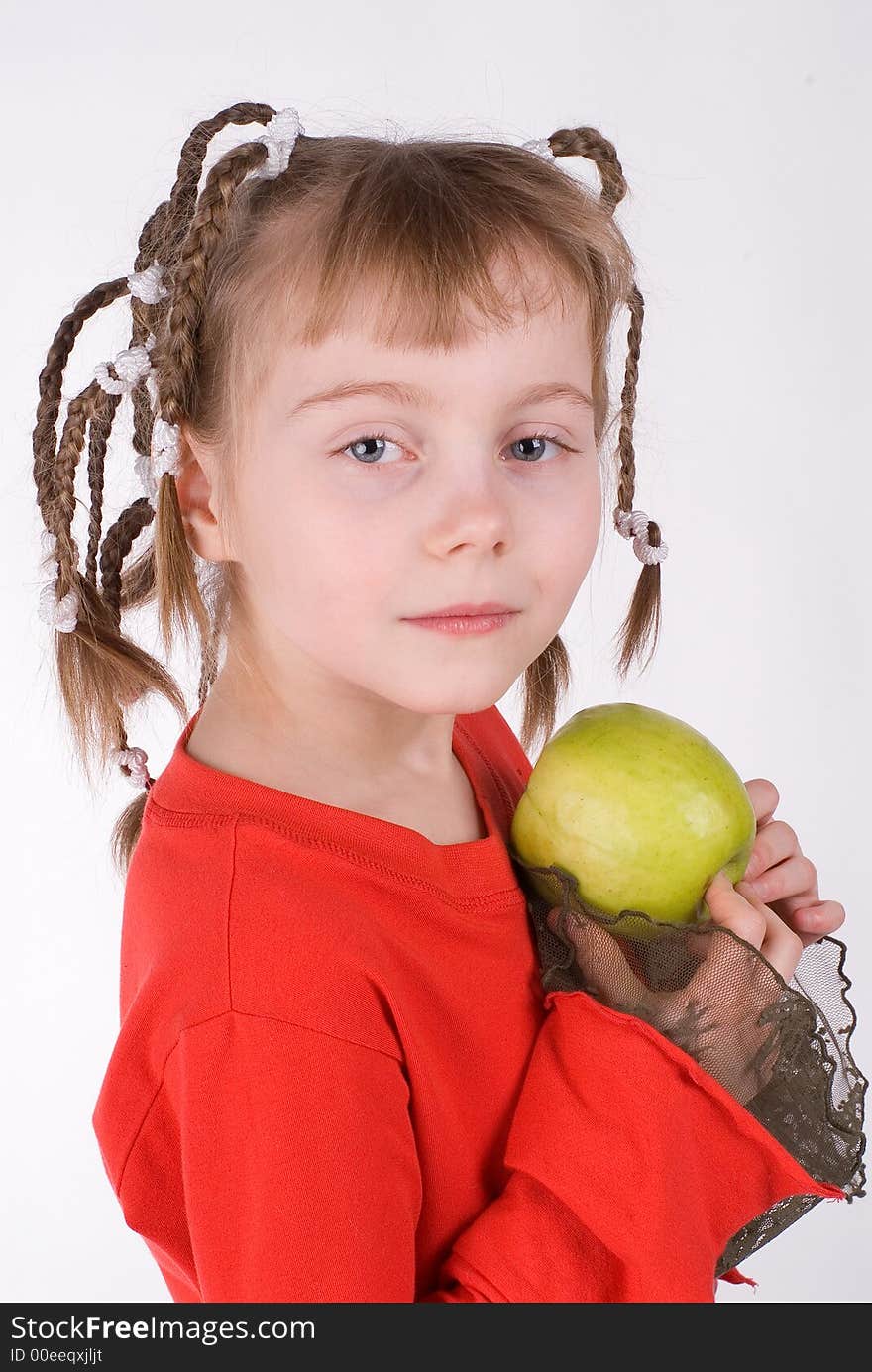 The girl in a red dress with an apple on a white background. The girl in a red dress with an apple on a white background