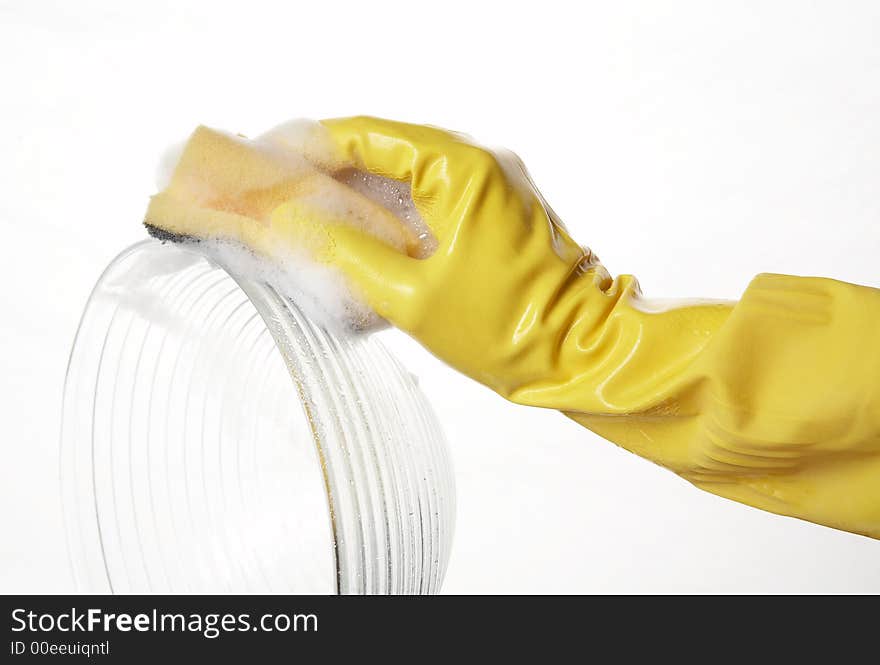 Hand in yellow rubber glove with yellow sponge and foam and plate. Hand in yellow rubber glove with yellow sponge and foam and plate