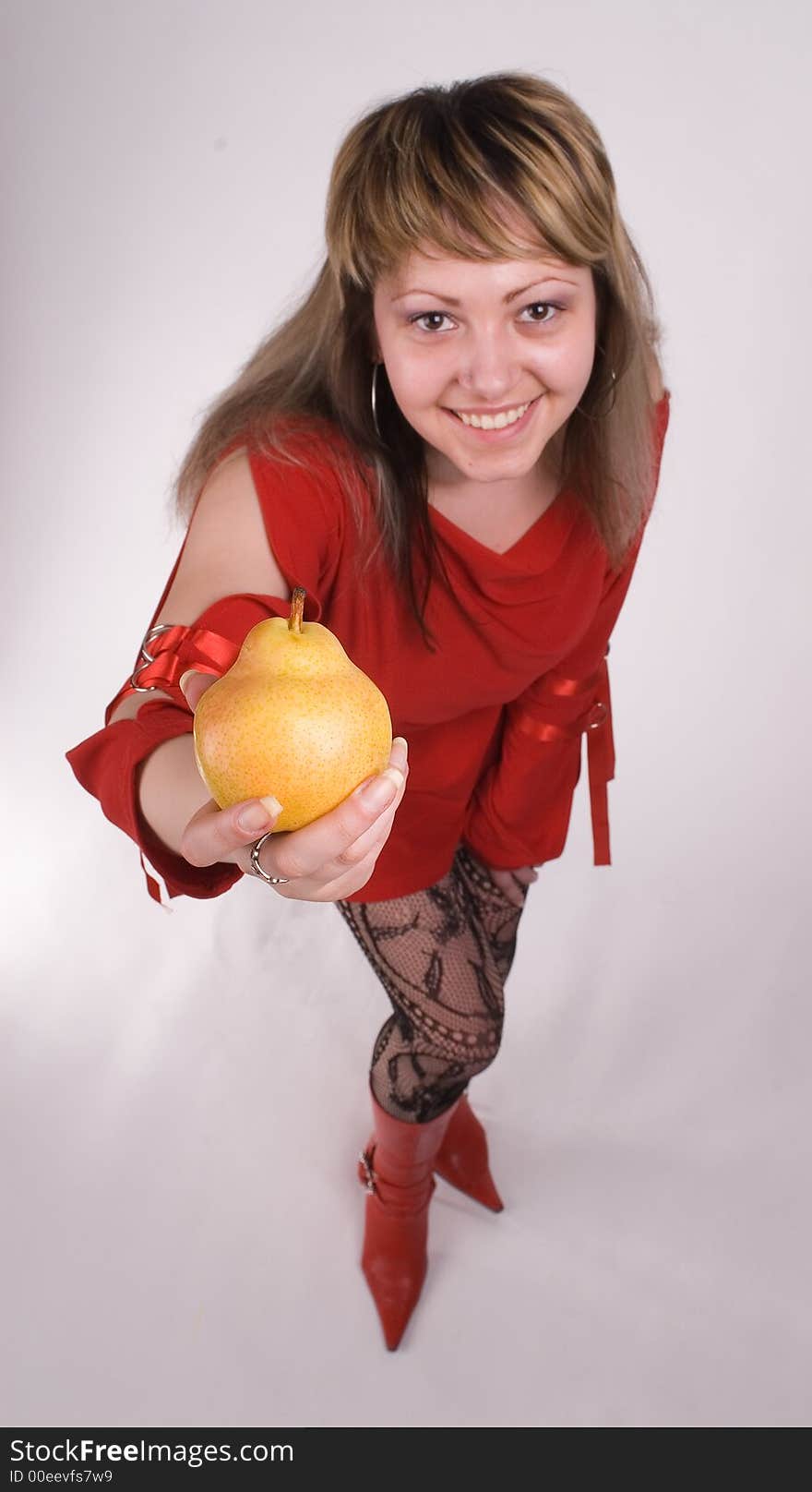 The girl in a red dress with a pear on a white background. The girl in a red dress with a pear on a white background