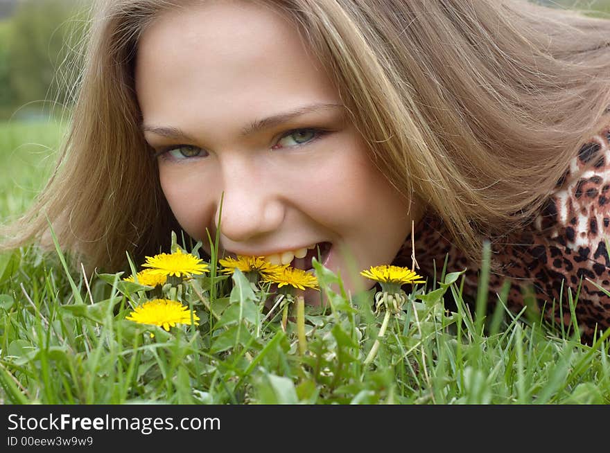 Pretty girl bites dandelion