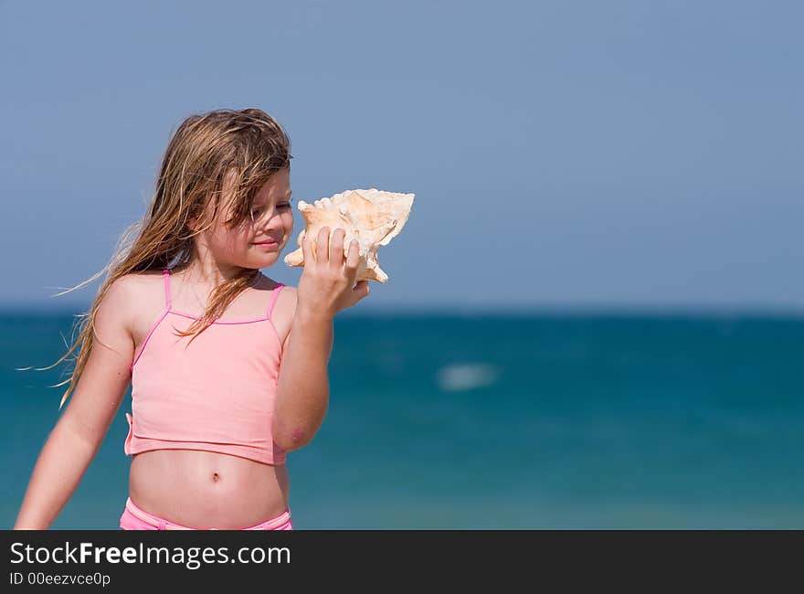 Young girl finds shell on beach. Atlantic Ocean, Florida east coast. Young girl finds shell on beach. Atlantic Ocean, Florida east coast