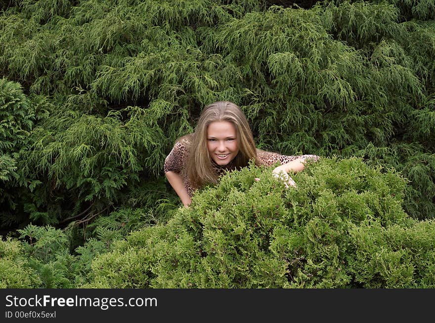 Cute girl hiding in bushes